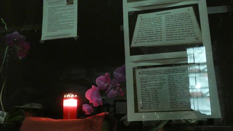Mahnwache in der Geschäftsstelle DIE LINKE Wandsbek Kerze im Fenster, daneben Zettel die über Opfer des Nationalsozialismus informieren