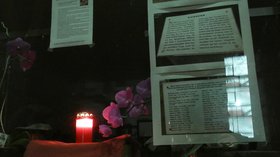 Kerze im Fenster, daneben Zettel die über Opfer des Nationalsozialismus informieren