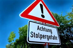Bild Verkehrsschild Achtung mit zusätzlichem Schild mit der Aufschrift "Stolpergefahr"