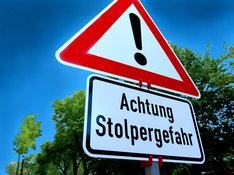 Bild Verkehrsschild Achtung mit zusätzlichem Schild mit der Aufschrift "Stolpergefahr"