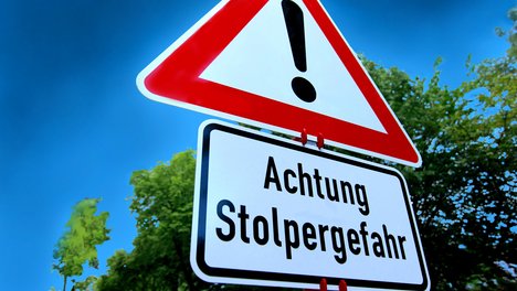 Bild Verkehrsschild Achtung mit zusätzlichem Schild mit der Aufschrift "Stolpergefahr"